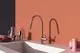 Küchenarmatur in Chrom von Ideal Standard. Der Wasserhahn hat einen geschwungenen Auslauf und ist in einem modernen Ambiente mit hellen Wänden und einer Spüle platziert.
